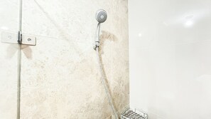 A shower with a handheld showerhead and a wall-mounted control panel. - Modern Studio At Transpark Cibubur Apartment (Depok)