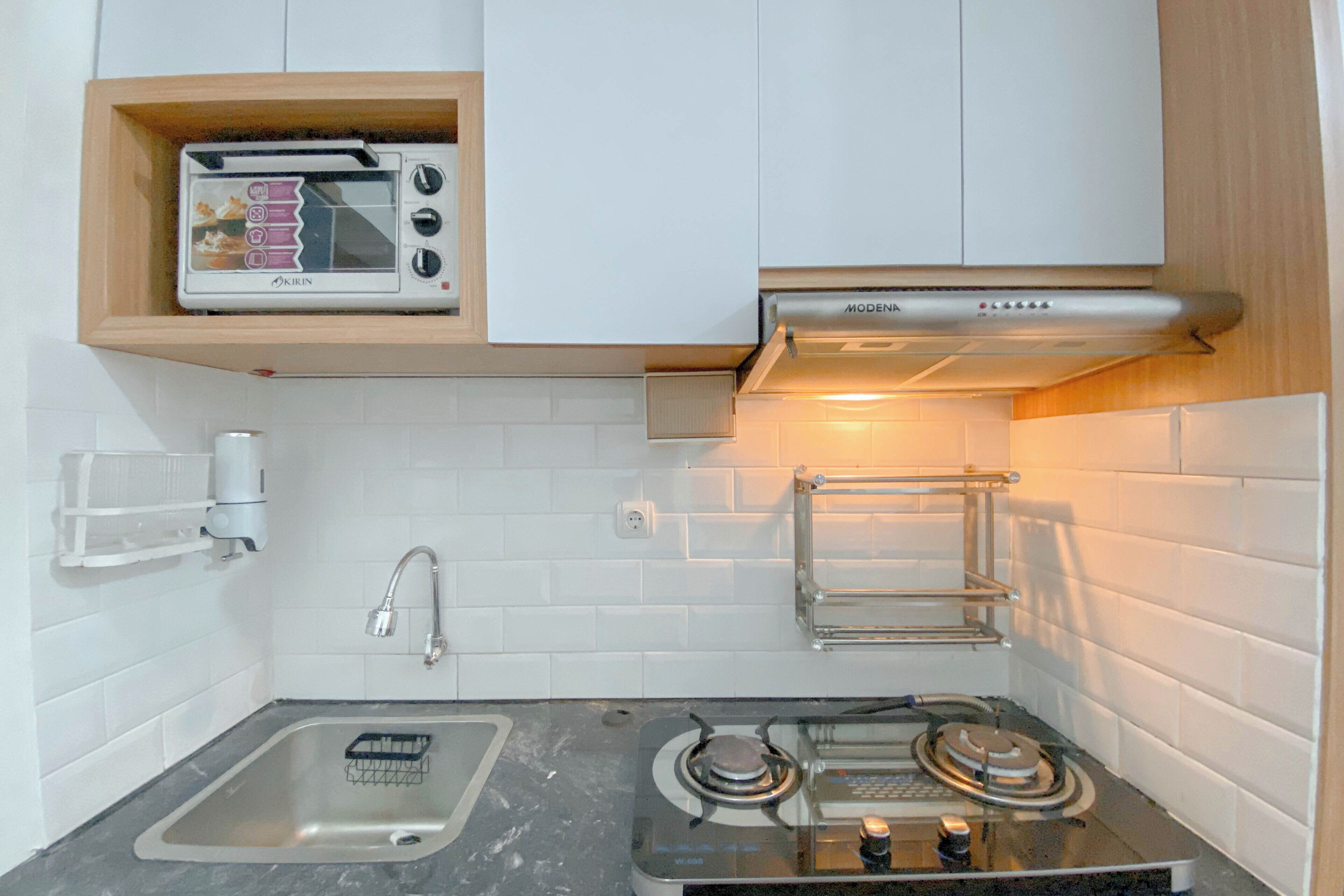 A kitchen with a built-in toaster, a gas stove, and a stainless steel sink.