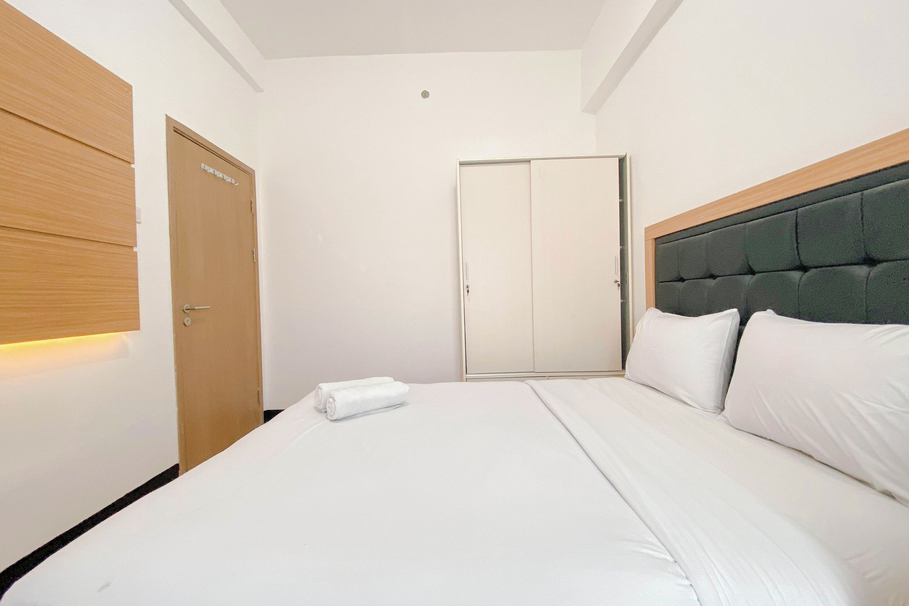 Une chambre d’hôtel avec un lit, une armoire et une porte.