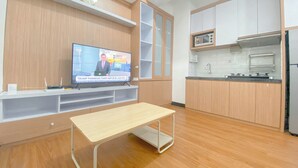 A modern kitchen with wooden cabinets, a built-in microwave, and a stainless steel refrigerator. - Modern 2Br Apartment At Cordova Edupartment Semarang (Semarang)