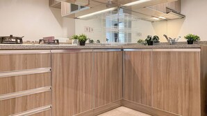 Une cuisine moderne avec des meubles en bois, un plan de travail en granit et des appareils électroménagers en acier inoxydable.