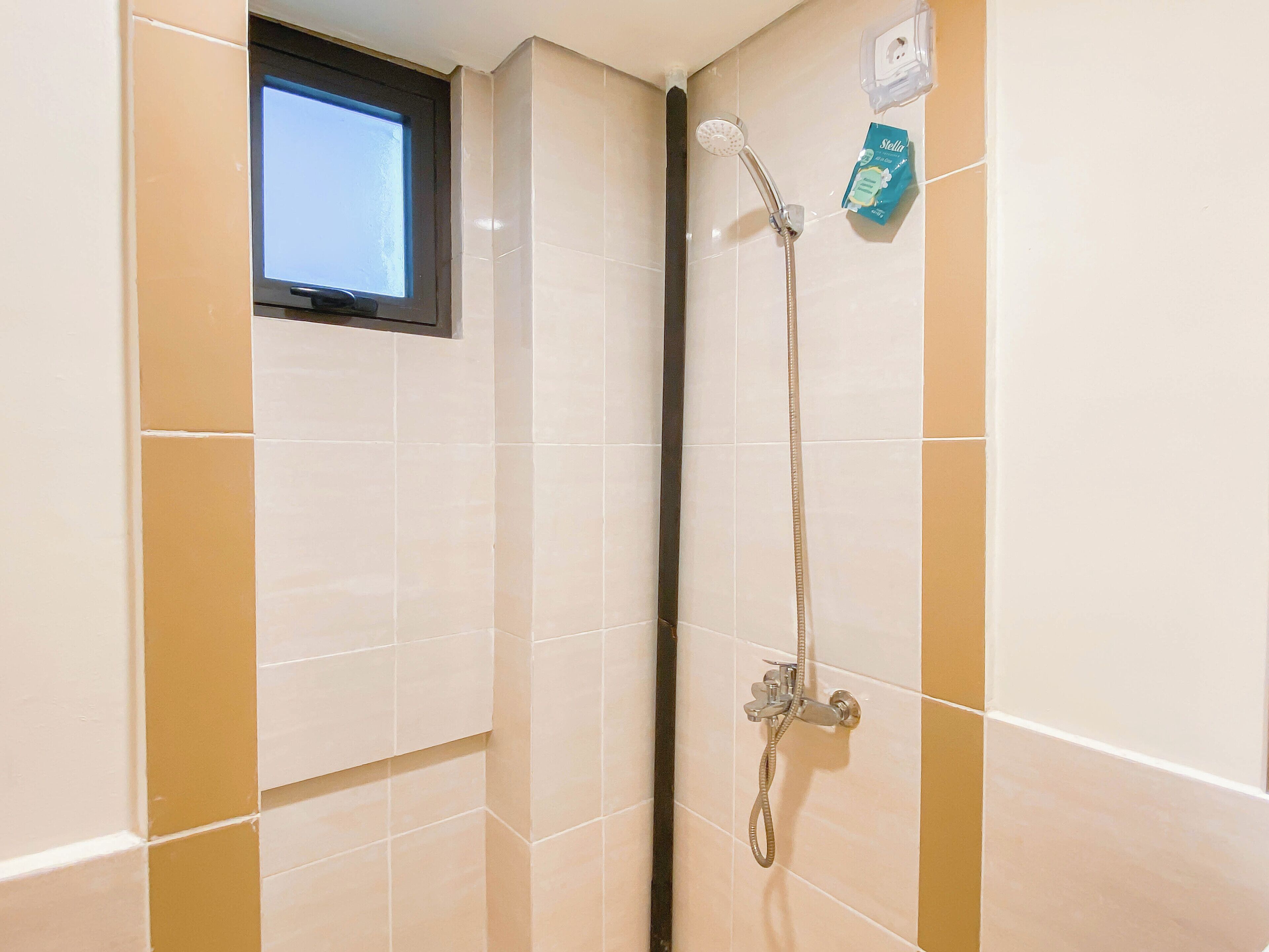 Eine Dusche mit Handbrause und einer fest installierten Armatur.