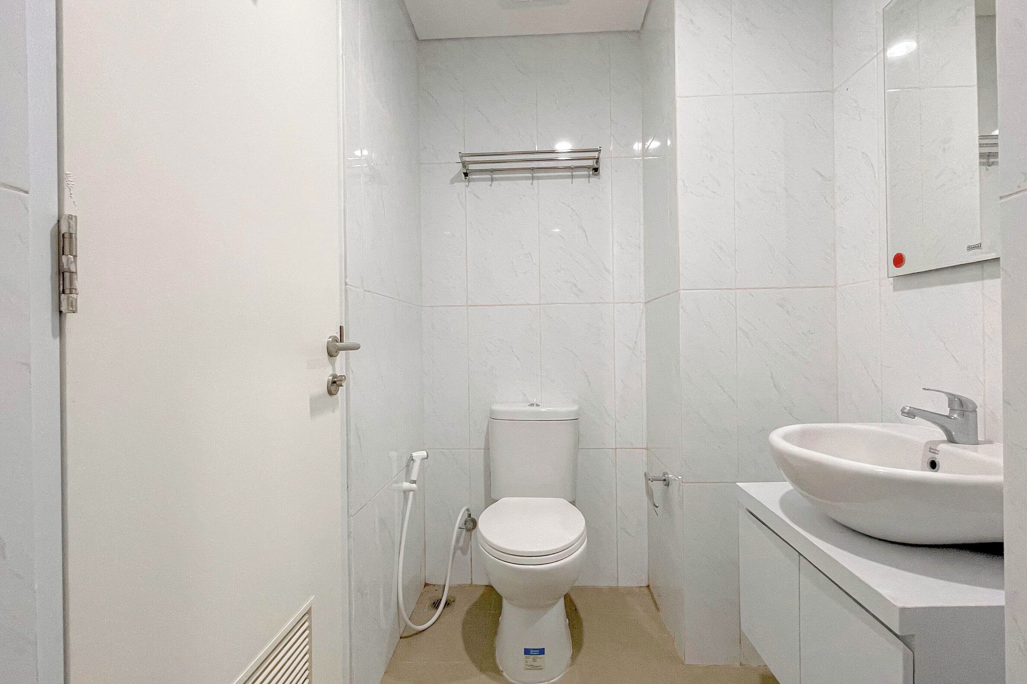 Un baño moderno con inodoro, lavamanos y ducha.