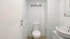 Un baño pequeño y moderno con inodoro, lavamanos y espejo.