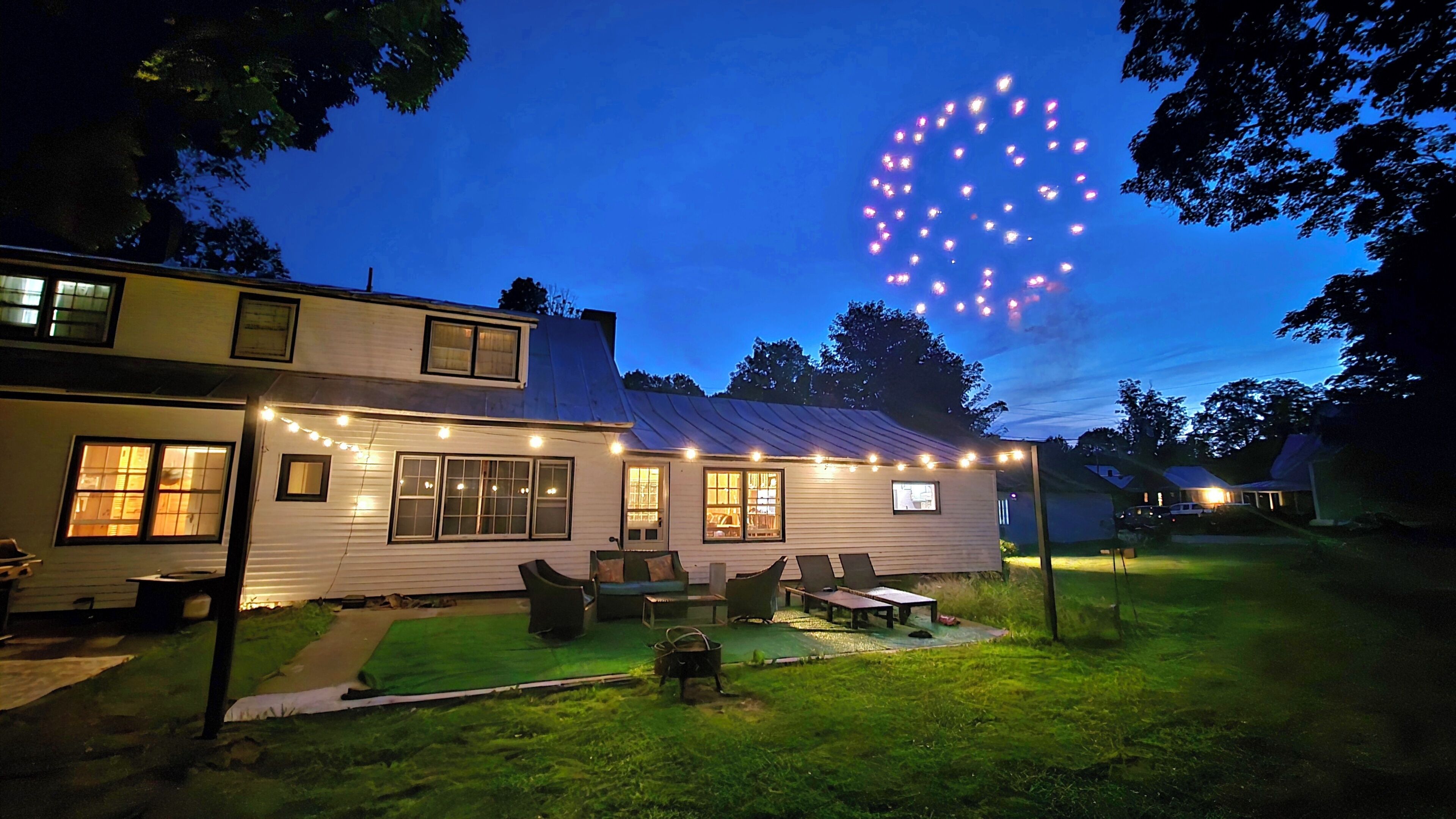 A house with a deck, outdoor lighting, and a grassy yard.