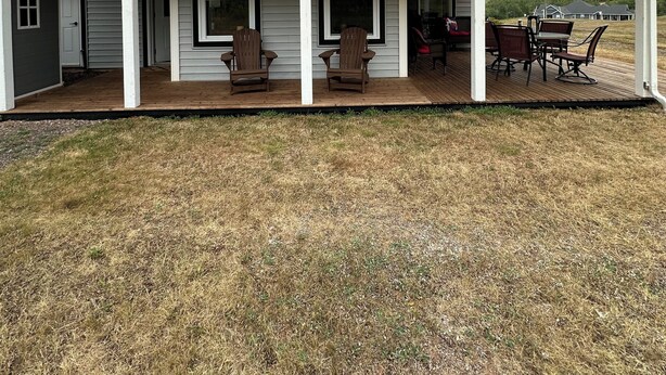 A single-story house with a covered porch, two Adirondack chairs, and a dining table with four chairs. - Golf, Beach & Great Local Eats! This condo unit is minutes is away from it all. (Breadalbane)