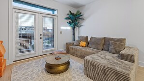A living room with a sofa set, a coffee table, and a potted plant. - 3/3 sauna, arcade, play couch, 70" TV, fire pit, balconies, 6 min from downtown (Chattanooga)