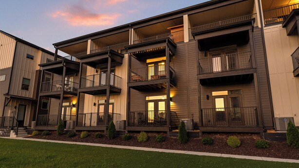 A multi-story residential building with balconies, a covered front porch, and a landscaped front yard. - 3/3 sauna, arcade, play couch, 70" TV, fire pit, balconies, 6 min from downtown (Chattanooga)