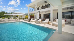 A modern poolside area with lounge chairs and a clear blue pool.