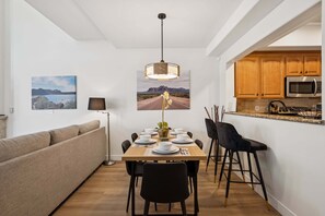 A modern dining area with a wooden table, black chairs, and a pendant light. - Modern 3-Bed, 3-Bath Townhouse in the Heart of Scottsdale (Scottsdale)