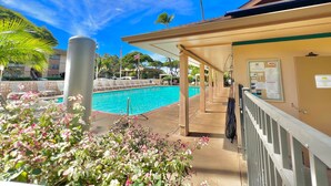 A pool area with lounge chairs and a covered walkway. - Tropical stay with full kitchen (Kihei)