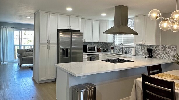 A modern kitchen with white cabinets, stainless steel appliances, and a central island. - Gorgeous 3-bedroom 4 bed home in San Diego (San Diego)