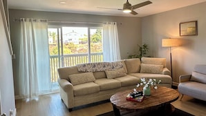 A living room with a sofa, a coffee table, a ceiling fan, and a view through the window. - Gorgeous 3-bedroom 4 bed home in San Diego (San Diego)
