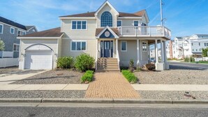 A two-story house with a front porch, a garage, and a driveway.