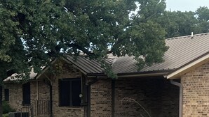 A stone patio leading to a brick house with a covered garage.