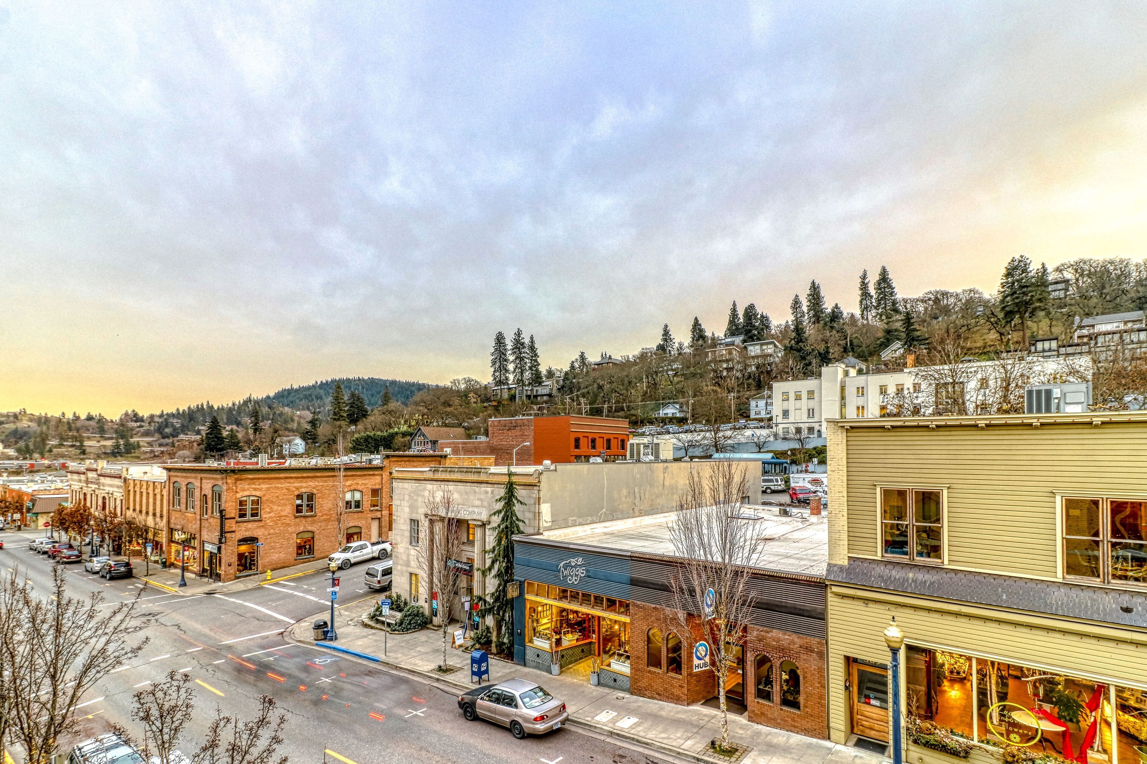 A downtown street with buildings, cars, and a clear sky.