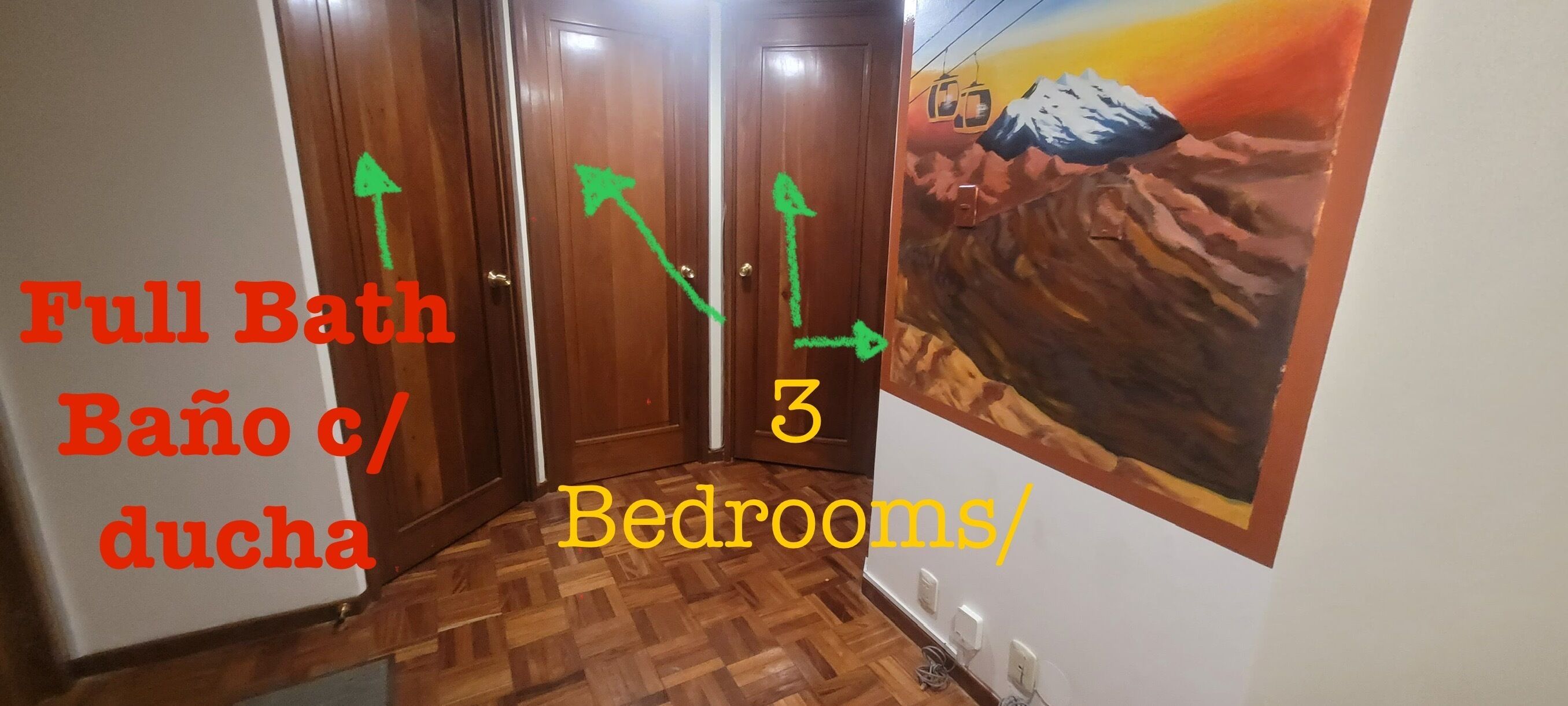 Un pasillo con puertas de madera, un cuadro de un paisaje montañoso, y texto que indica tres dormitorios y un baño completo.
