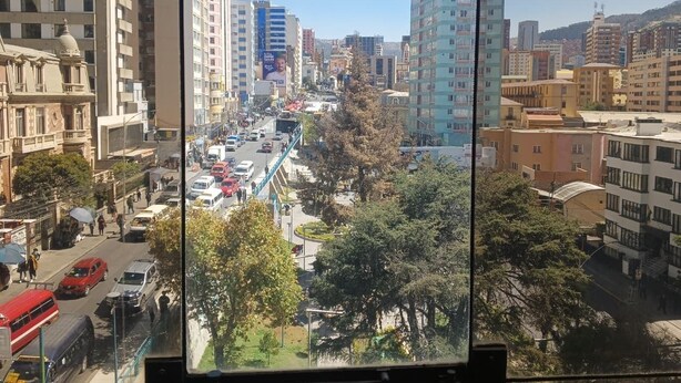 Un paisaje urbano con edificios altos, una calle concurrida y una acera para peatones.