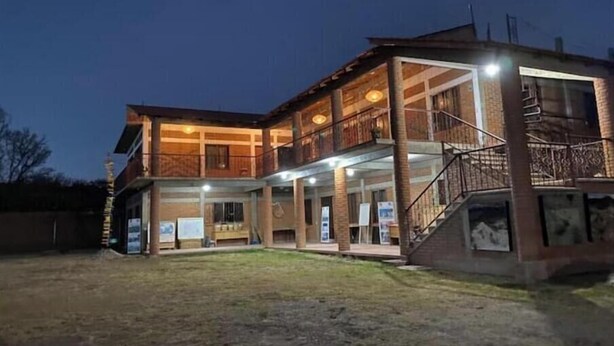 A two-story building with a balcony on the upper floor, a covered outdoor area, and a staircase leading to the upper level.
