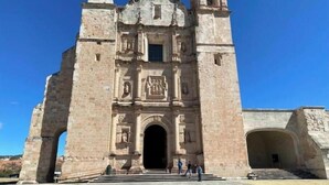 A historic stone church with a bell tower and an arched entrance.