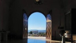Un amplio salón con un arco alto que da a un espacio exterior.