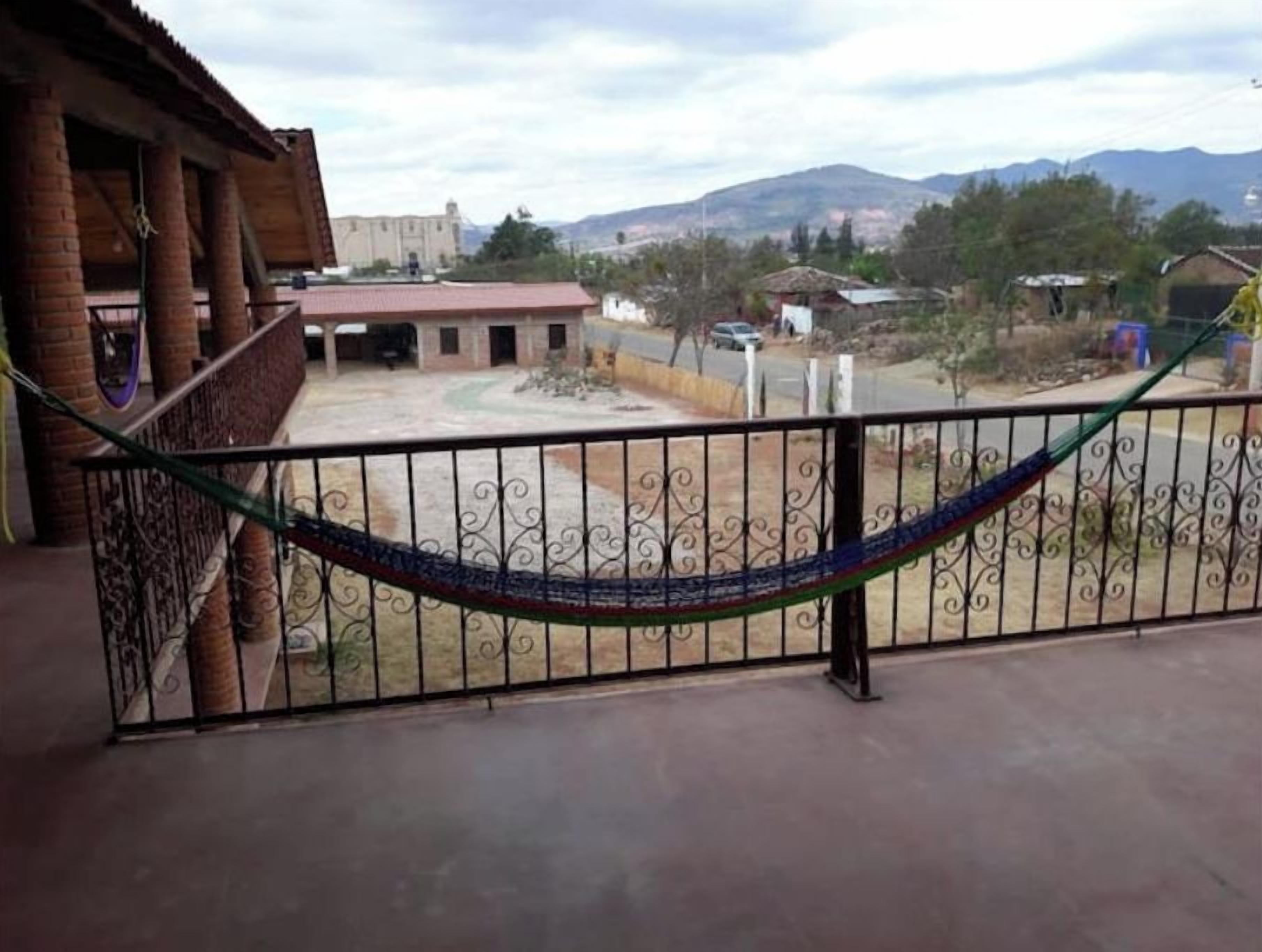 Un balcón con baranda de metal y una hamaca.