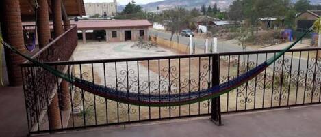 A balcony with a metal railing and a hammock.