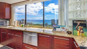 Una cocina con un ventanal que da a una vista de la ciudad y el océano.