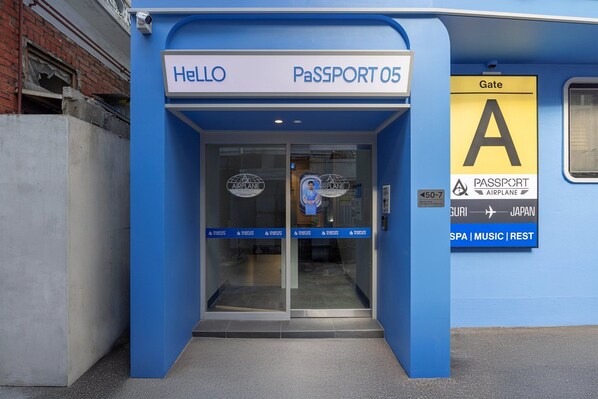 A blue entrance with signs reading 'HELLO' and 'PASSPORT 05'. - Stay Passport Airplane Guri (Guri)