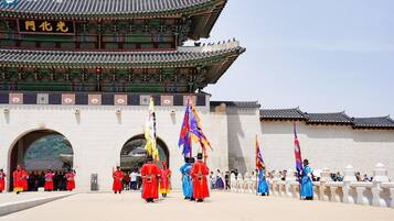 A traditional Korean gate with guards in colorful uniforms and flags.