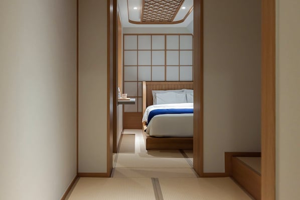 A narrow hallway leading to a bedroom with a wooden headboard and a bedside table.