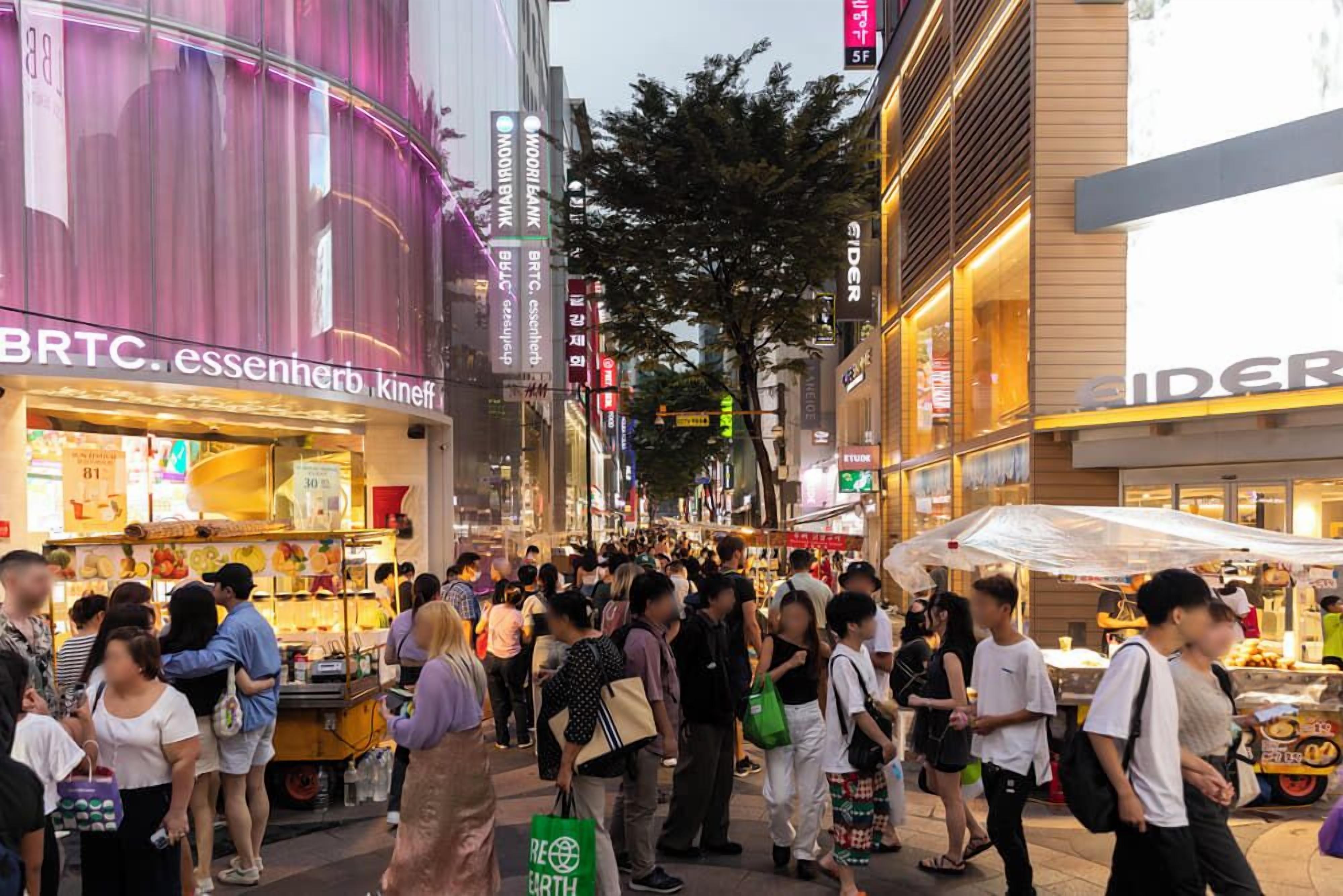 A busy urban street with various shops and pedestrians.