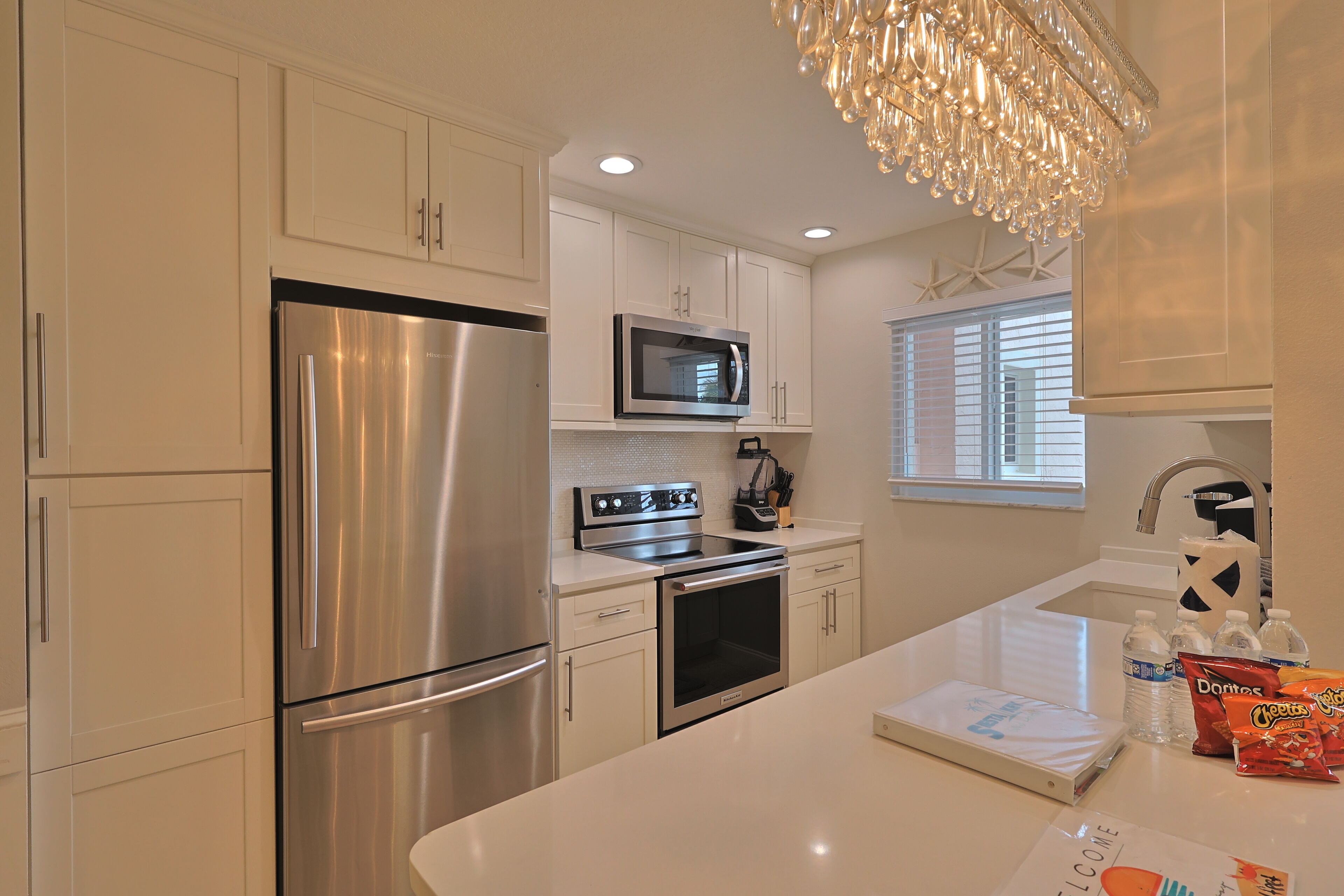A modern kitchen with stainless steel appliances, a built-in microwave, and a large island with a sink.