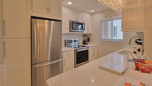 A modern kitchen with stainless steel appliances, a built-in microwave, and a large island with a sink.