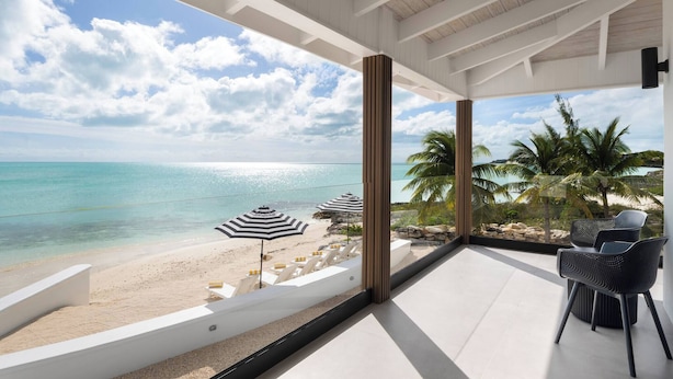 A balcony with a view of a beach and ocean. - Opaline Villa -3BR 2bath Oceanfront (Providenciales)