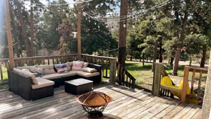 A wooden deck with a sofa and a hanging light fixture.