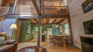 A rustic cabin interior with a loft bedroom, a dining area, and a kitchen. - Entire cabin in Speculator, New York (Speculator)