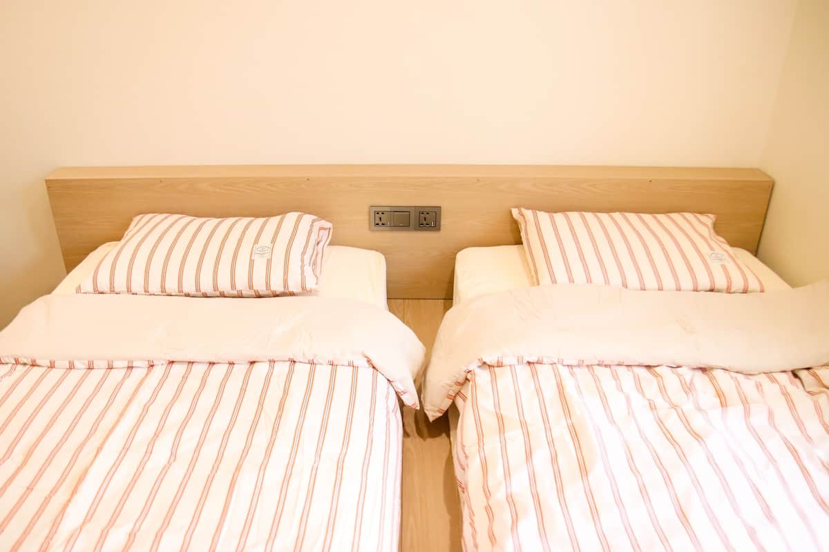 A double bed with striped bedding and a wooden headboard.