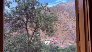 A window view of a mountainous area with buildings in the background. - 3A retreat (Sti Fadma)