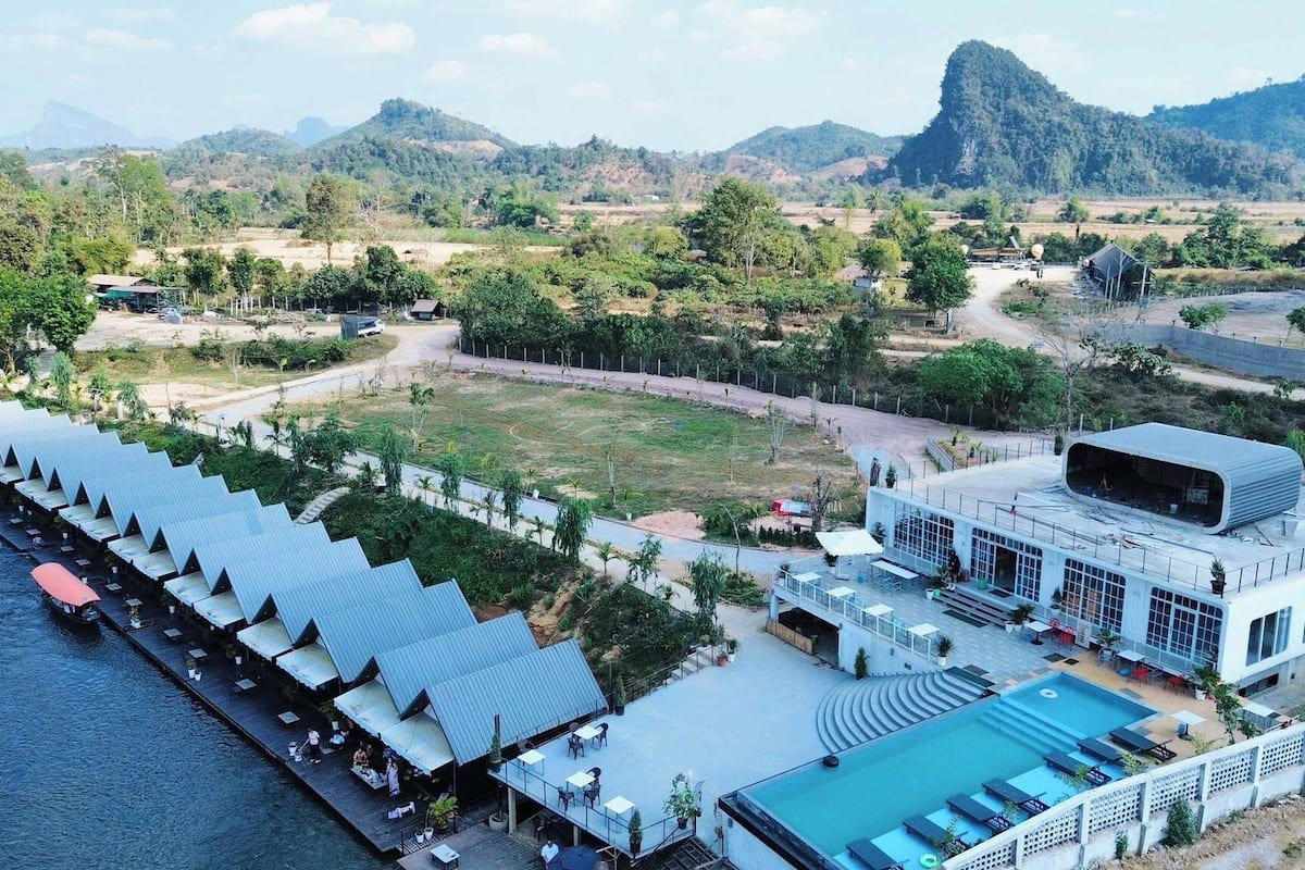 Ein Resort mit langer Anlegestelle, Schwimmbad und einem modernen Gebäude mit großen Fenstern.