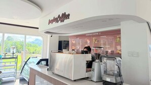 Eine Theke in einem Café mit Karte, einer Kaffeemaschine und einer Mühle.