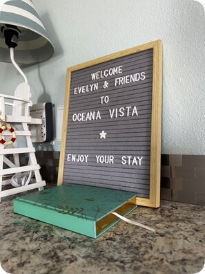 A welcome sign for 'Evelyn & Friends' at Oceana Vista, with a star symbol and a message to 'Enjoy Your Stay.' - Charming 2-bedroom house in gorgeous PCB just steps away from the beach (Panama City Beach)