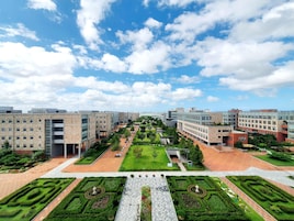 Un campus moderno con edificios rectangulares, césped verde y diseños de jardín geométricos.