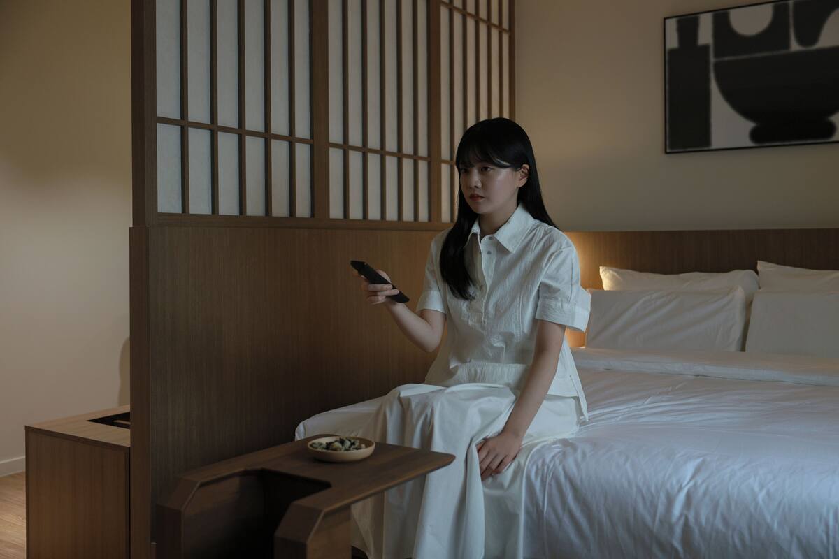 A room with a bed, a nightstand, and a wall with a traditional design.