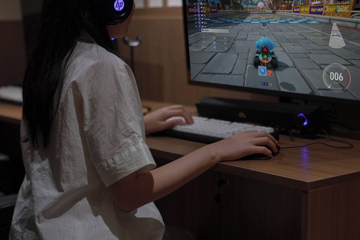 A person playing a racing video game at a computer.