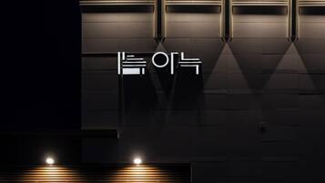 A modern building facade with illuminated signage and recessed lighting.
