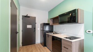 A compact kitchen with a microwave, refrigerator, and dishwasher.