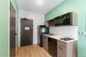Una cocina compacta con microondas, refrigerador y lavavajillas.