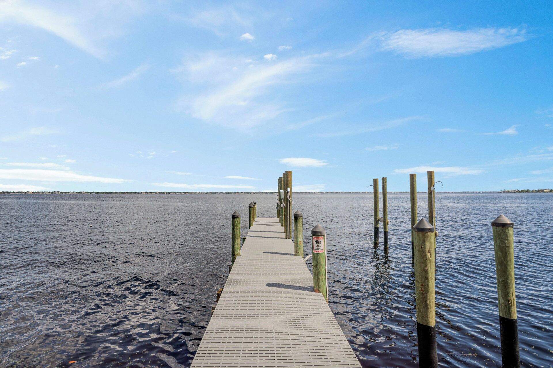 Un muelle de madera que se adentra en aguas tranquilas bajo un cielo despejado.