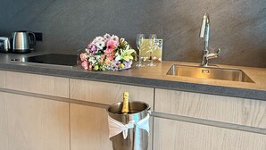 Et moderne køkken med indbygget vask, stålstål-hvidevarer og en dekorativ blomsteropsætning.